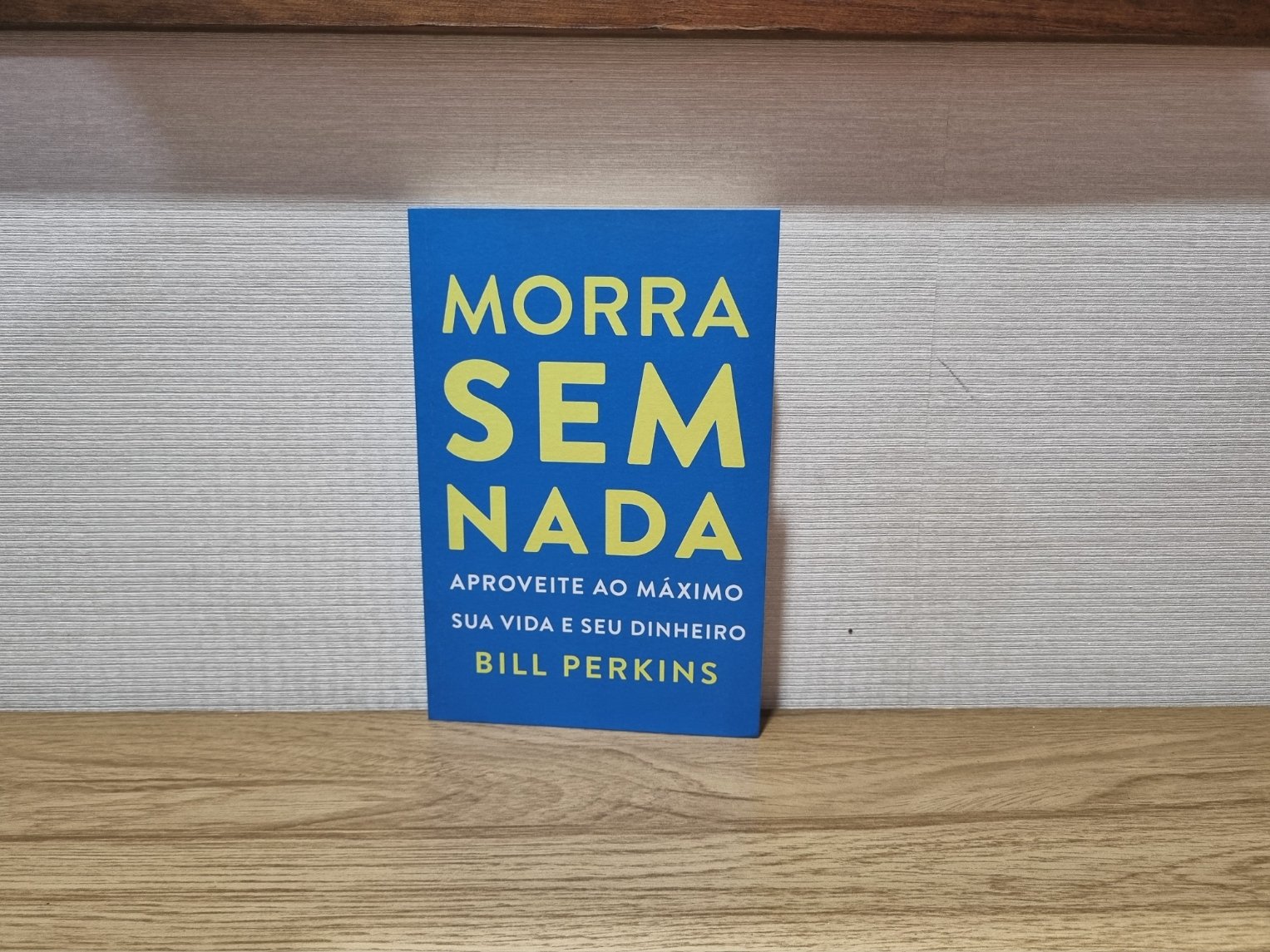 Foto autoral da capa do livro Morra Sem Nada de Bill Perkins sobre uma bancada de madeira.