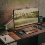 Configuração estilosa de mesa de escritório em casa com computador, laptop, smartphone e equipamento de áudio.
