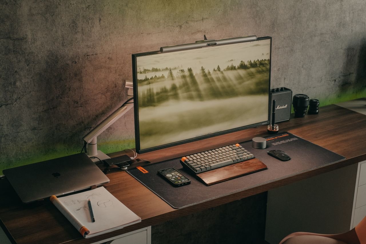 Ergonomia para Home Office: O Setup do Investidor Configuração estilosa de mesa de escritório em casa com computador, laptop, smartphone e equipamento de áudio.